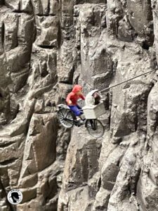 Image of a miniature of ET and Elliot riding a bike in front a mountain 