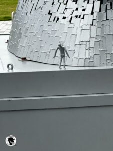 Image from the scale sculpture of a man looking up at the scale model of the Kelpie to show perspective next to a human. 
