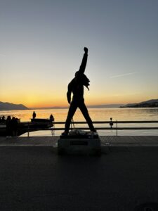 Image of the Freddie Mercury statue in Montreux.  The angle leverages the sunset to have the statue as a silhouette.